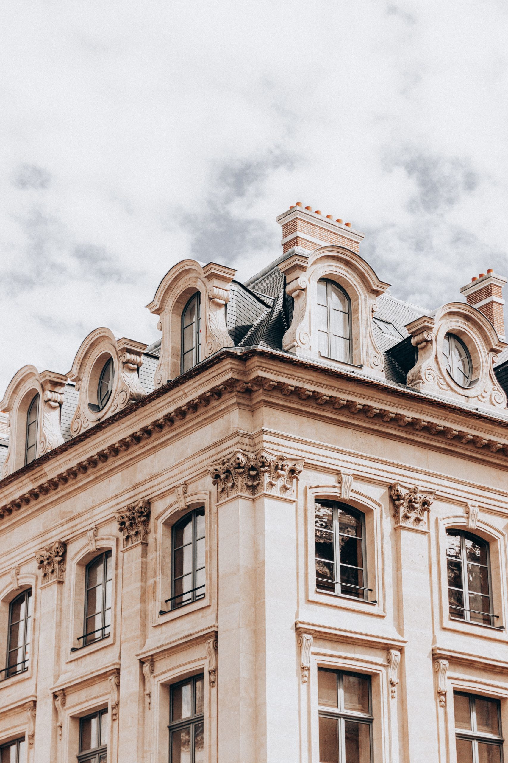 Photo d'un immeuble de style haussmannien, avec ses élégantes façades en pierre et ses grandes fenêtres.